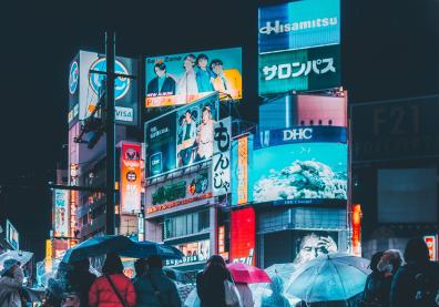 Un groupe de personnes sous les parapluies sur un grande place à Shibuya, Japon