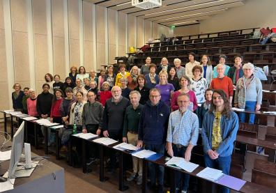 Un groupe de personnes sont debout dans un auditorium en choeur