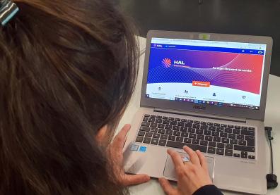 Une femme de dos écrit sur son ordinateur