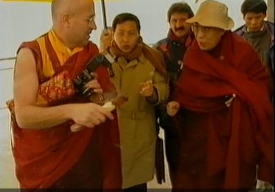 Le Dalaï Lama en visite, entouré de plusieurs personnes