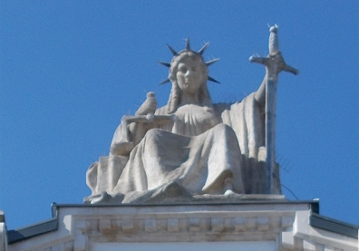 Statue avec une couronne et une épée sur fond bleu ciel