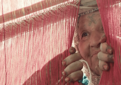 Une vieille dame entrouvre un rideau et regarde 