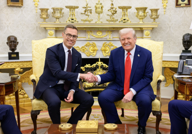 Photo de deux hommes en costume bleu qui se serrent la main devant une cheminée dorée