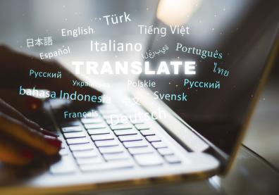 Mains utilisant un ordinateur portable avec texte "traduction" et plusieurs noms de langues étangères