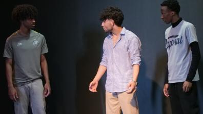3 étudiants sont debout et jouent une scènette