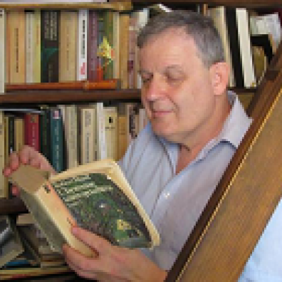 Thomas Szende assis sur les marches de sa bibliothèque,  feuillette "L'homme sans qualités" de Robert Musil.
