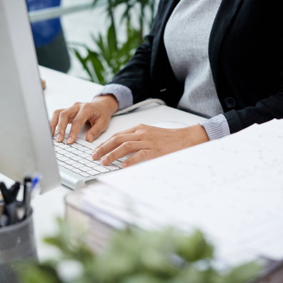 Femme derrière un bureau qui travaille sur son ordinateur