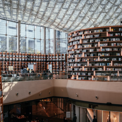 Tours de livres avec en haut de l'image des baies vitrées et un toit en verre