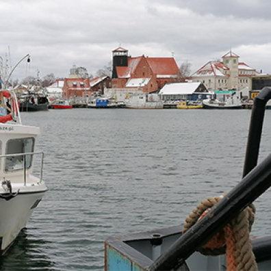 Photo d'un port sous la neige avec des bâteaux et des maisons