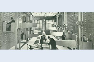 Salle d'archives en noir et blanc avec des personnes travaillant