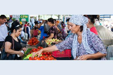 Femme ouzbek déposant des tomates sur son étal lors d'un marché à Tachkent, Ouzbékistan 