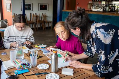 Des personnes assises autour d'une table dessinent