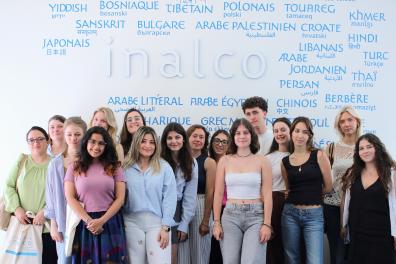 Participantes et participant du programme intensif hybride “Discover French Culture in Paris” devant le mur de langues à l'Inalco