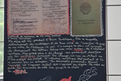 Sur un tableau deux documents de type certificats soviétiques sont accrochés et en dessous un texte