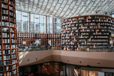 Tours de livres avec en haut de l'image des baies vitrées et un toit en verre