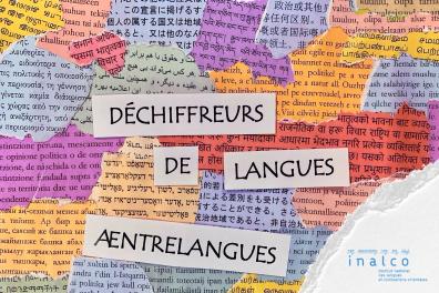Bandes de papier découpées sur lesquelles sont inscrites les noms des deux concours, Æntrelangues et Déchiffreurs de Langues, posées sur un tas de petites coupures de journaux ou de livres en langues étrangères