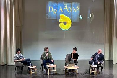 Une scène sur laquelle se trouvent 4 personnes assises micro à la main et discutent 