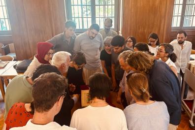 Un groupe de personnes consultent un manuscrit à la bibliothèque