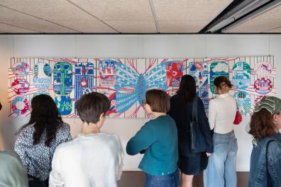 Un groupe de personne regardent une fresque colorée 