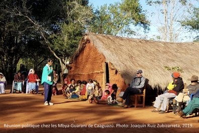 Réunion politique chez les Mbya-Guarani de Caaguazu. Une quinzaine de personnes assises dehors devant une maison.