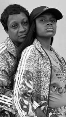 Portrait de deux femmes, la maman prend dans ses bras sa fille de dos