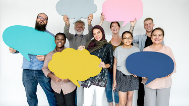 Un groupe de personnes portent dans leurs mains des bulles de paroles de couleurs et formes différentes 