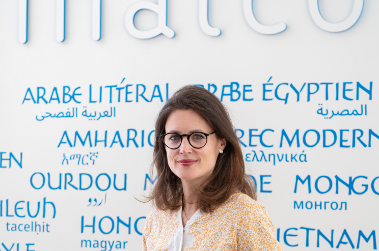 Portrait de Delphine Allès devant le mur des langues de l'Inalco