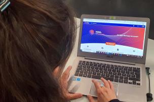 Une femme de dos écrit sur son ordinateur