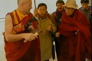 Le Dalaï Lama en visite, entouré de plusieurs personnes