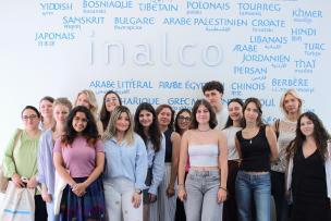 Participantes et participant du programme intensif hybride “Discover French Culture in Paris” devant le mur de langues à l'Inalco