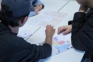 Students with their backs to a desk working with documents