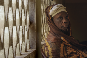 Une dame âgée vêtue d'un pagne est assise