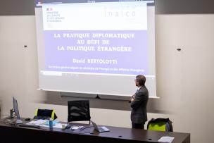 David Bertolotti, secrétaire général adjoint du ministère de l'Europe et des Affaires étrangères, se tient debout devant un écran de projection sur lequel est écrit le sujet de son intervention : "La pratique diplomatique au défi de la politique étrangère"