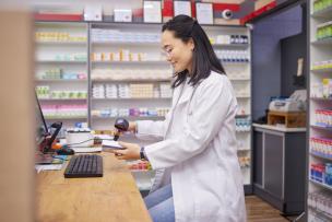 Young female pharmacist scanning medications