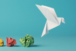 Un oiseau en papier s'envole et laisse 3 boules de papiers derrière lui