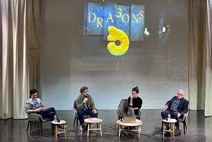 Une scène sur laquelle se trouvent 4 personnes assises micro à la main et discutent 