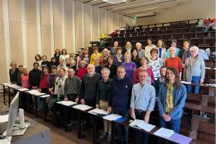 Un groupe de personnes debout sur les bancs de l'auditorium 