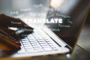 Mains utilisant un ordinateur portable avec texte "traduction" et plusieurs noms de langues étangères
