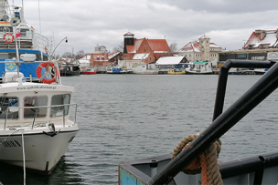 Photo d'un port sous la neige avec des bâteaux et des maisons