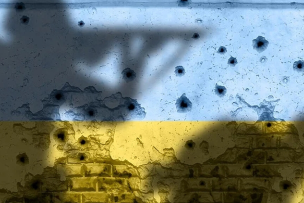 Ombres de soldats en joue sur un mur criblé de balles