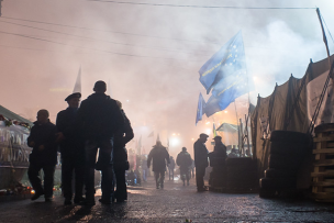 Rue enfumée avec des barricades et des soldats de dos